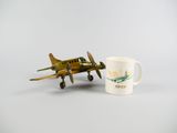 un petit avion miniature à côté d'une tasse de café