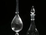 deux vases transparents contenant des fleurs rouges, sur fond noir