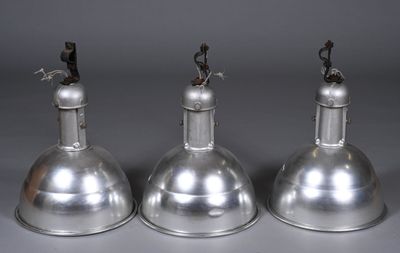 trois lampes en métal argenté sur fond gris