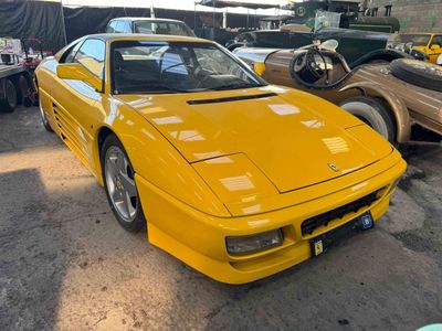 a yellow sports car parked in a lot next to other cars