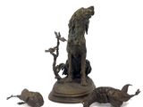 statue en bronze représentant un chien et quatre oiseaux, posée sur un socle