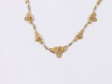a close up of a gold necklace on a white background