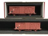 deux wagons rouges dans une boîte sur fond blanc