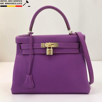 un sac à main violet posé sur une table blanche