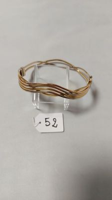 un gros plan d'un bracelet en fil métallique posé sur une surface blanche