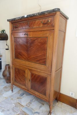 a wooden cabinet with a marble top in the corner of a room