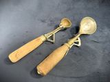 pair of antique brass spoons with wooden handles on a black background