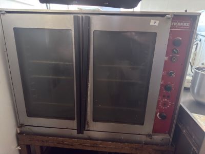 two ovens that are sitting on top of a wooden table