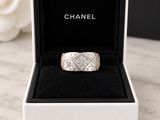 a close up of a ring in a box with a rose in the background