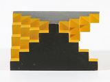 une image représentant une sculpture noire et jaune posée sur une surface blanche