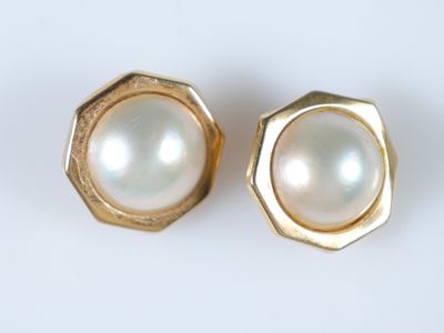 une photo d'une paire de boucles d'oreilles en perles posées sur une surface blanche