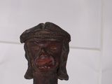 wooden head of a man with a hat on top of a pole