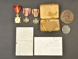 several medals and a letter are sitting on a table next to a piece of paper