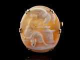 an oval carved shell with a woman sitting on a table