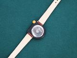 a close up of a watch sitting on top of a green surface