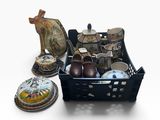 un panier noir rempli d'objets variés posé sur une surface blanche
