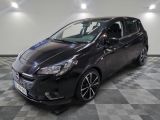 une voiture noire est garée dans une pièce au sol en damier