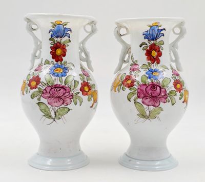 une paire de vases blancs ornés de motifs floraux sur fond blanc