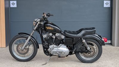 a black motorcycle parked in front of a garage door