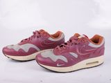 La Nike Air Max est rose et grise, avec une semelle marron clair