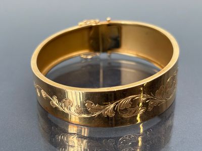 gros plan d'un bracelet en or sur une table