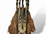 an image of a wooden mask hanging on a wall