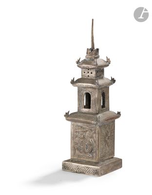 an image of a silver statue of a pagoda with a bird on top of it