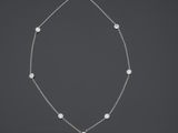 un collier de perles blanches et de diamants monté sur une chaîne en argent