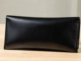 a black leather wallet sitting on top of a wooden table