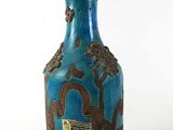 a blue vase with a design on it sitting on a table