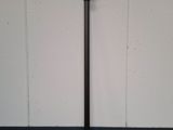 a black pole with a blue handle on the floor