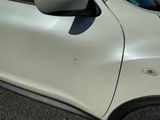 a white car with a mirror on the side of the road