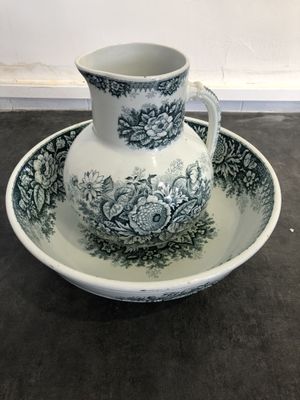 a picture of a pitcher and a saucer on a table
