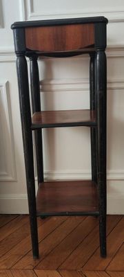 a small table with a shelf in the corner of the room