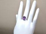 an amethorate and diamond ring on a mannequin hand