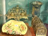 une vitrine remplie d'objets anciens, derrière une paroi en verre