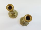 two gold vases on a white surface with a white background