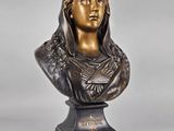a bronze bust of a woman with a bird on her head
