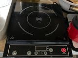 une plaque de cuisson noire surmontée d'un brûleur noir