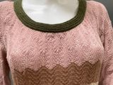 an image of a mannequin wearing a pink sweater and green belt