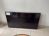 a flat screen tv sitting on the floor next to a coffee table