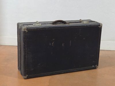 a black suitcase sitting on the floor next to a white wall