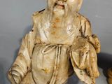 two figurines of a man sitting next to each other