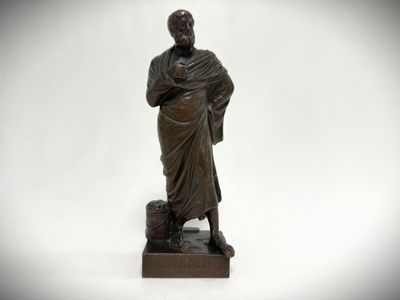 an old bronze statue of a man holding a cane