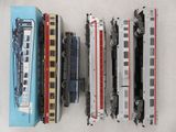 Plusieurs trains miniatures sont alignés les uns à côté des autres sur une table