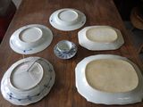 many plates and bowls sitting on a wooden table