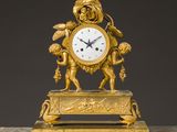 une image représentant une horloge en or ornée de chérubins, posée sur un socle en marbre