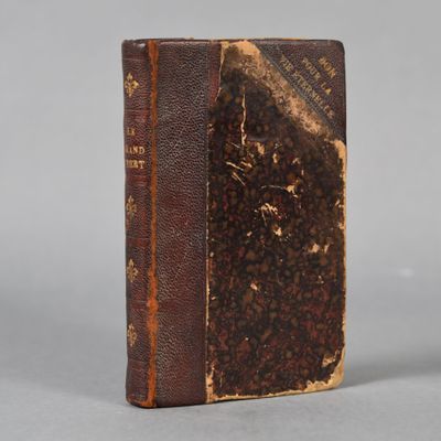 an old book sitting on top of a white surface