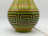 a green vase with a black and yellow design on it