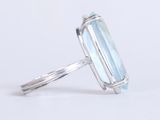 a close up of a ring with an aquamarine stone in it